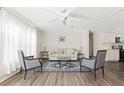 Bright living room featuring neutral walls, ceiling fan and modern furniture arrangement and hardwood floors at 3323 Parlow Ave, Spring Hill, FL 34606