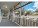 Cozy screened front porch with view of front yard and neighborhood at 3540 Linkwood St, New Port Richey, FL 34652