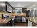 Modern kitchen features stainless steel appliances, granite countertops, and dark wood cabinetry at 3540 Linkwood St, New Port Richey, FL 34652