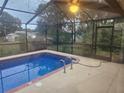 A screened-in pool featuring blue tile and a patio area for lounging and relaxing at 9179 Gillmar St, Spring Hill, FL 34608