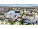 Scenic aerial view of a residential neighborhood featuring houses, a lake, and lush greenery at 12824 Tikal Way, Trinity, FL 34655