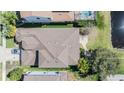 Top-down aerial view of a house showcasing its roof, landscaping, and proximity to a pond at 12824 Tikal Way, Trinity, FL 34655