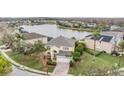 Aerial view showcasing a home with a pool, a large backyard, and a scenic lake at 1337 Halapa Way, Trinity, FL 34655