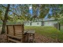 Exterior view of a well-maintained home with lush backyard under the shade of a mature tree at 16325 Hibiscus Rd, Brooksville, FL 34601
