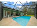 Enclosed pool area with seating and screen enclosure around a sparkling, in-ground pool at 16325 Hibiscus Rd, Brooksville, FL 34601