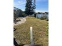 Lush backyard featuring a well-maintained lawn and charming walkway to a serene waterfront at 5771 Catskill Rd, Holiday, FL 34690
