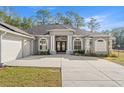 The exterior of the home has elegant architectural features, beautiful landscaping, and an attached garage at 7482 Winter St, Brooksville, FL 34613