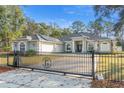 The home has an elegant gated entry, solar panels, beautiful landscaping, and a long driveway at 7482 Winter St, Brooksville, FL 34613