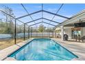 Inviting screened-in pool with an outdoor kitchen area and a covered patio with a seating area at 7482 Winter St, Brooksville, FL 34613