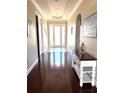 Inviting hallway with hardwood floors, decorative lighting, and elegant archway details at 1421 Apollo Beach Blvd, Apollo Beach, FL 33572