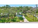 A scenic aerial shot reveals a well-placed home with a large lawn, shaded by mature trees at 1888 Douglas Ave, Dunedin, FL 34698