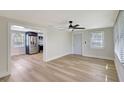 Open-concept living room with hardwood floors, neutral walls, and views into the updated kitchen at 1888 Douglas Ave, Dunedin, FL 34698