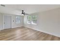 Bright living room featuring modern ceiling fan, fresh paint, wood floors, and natural light at 1888 Douglas Ave, Dunedin, FL 34698