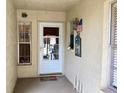 Cozy front porch with a welcome mat, an American flag, and a charming window view into the home's interior at 4529 Whitton Way # 214, New Port Richey, FL 34653