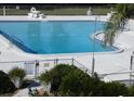 Community pool is surrounded by a fence and lush landscaping at 4801 Airport Rd # 208, Zephyrhills, FL 33542