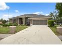 Charming single-story home features a well-manicured lawn, screened garage, and long driveway at 6112 Kinlock Ave, Spring Hill, FL 34608