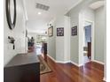 Bright hallway with hardwood floors, neutral walls, and a glimpse into the home's living areas at 10910 May Apple Ct, Land O Lakes, FL 34638