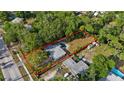 An aerial view of the property showcases a large backyard with a pool and lush trees at 1101 N Betty Ln, Clearwater, FL 33755