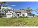 Angle shot of this charming single-story home with a well-manicured lawn and gray exterior at 11134 Horned Owl Rd, Weeki Wachee, FL 34614