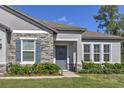 A close up of the front entrance features gray stonework and meticulously maintained landscaping at 11134 Horned Owl Rd, Weeki Wachee, FL 34614