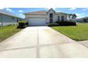 Charming single-Gathering home featuring a well-manicured lawn and a spacious driveway leading to an attached garage at 11204 Clear Oak Cir, New Port Richey, FL 34654