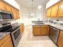 Well-lit kitchen featuring stainless steel appliances, granite countertops, and wooden cabinetry for a modern look at 11204 Clear Oak Cir, New Port Richey, FL 34654