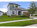 Attractive two-story home with verdant lawn, complemented by palm trees and tasteful landscaping at 17026 Shell Bay Dr, Land O Lakes, FL 34638