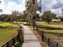 Long driveway leads to an estate featuring mature trees, a well-maintained lawn, and outbuildings at 5263 Spring Lake Hwy, Brooksville, FL 34601