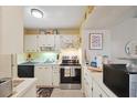 Cozy kitchen with white cabinetry, black appliances, and natural light at 6002 Laketree Ln # L, Temple Terrace, FL 33617