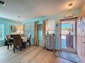 Bright dining area with a round table, stylish decor, and a view of the outdoors, adjacent to a pink door at 9332 Whitstone Ct, New Port Richey, FL 34655