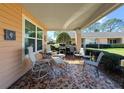 Covered patio area with outdoor seating and a grill, perfect for entertaining guests at 9332 Whitstone Ct, New Port Richey, FL 34655