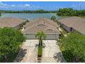 Aerial view of home featuring an oversized driveway and tranquil lake views at 9819 Bridgeton Dr, Tampa, FL 33626