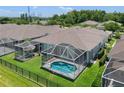 Aerial view of the screened in pool, set in a lush backyard with a black metal fence at 9819 Bridgeton Dr, Tampa, FL 33626