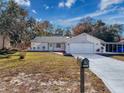 Charming home features a two-car garage, a covered carport, and a manicured lawn at 12242 Greenwood St, Brooksville, FL 34613