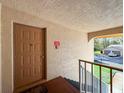 Exterior condo doorway with welcome mat showing a unit entry and a view to exterior parking at 13103 Cypress Hill Dr # B2, Hudson, FL 34669