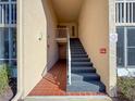 Condo entrance with stairway access showing exterior facade, ceramic tiled walkway and a wall-mounted fire hose at 13103 Cypress Hill Dr # B2, Hudson, FL 34669