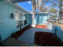 Charming home featuring a red gate, a large tree, and manicured landscaping at 1817 Dartmouth Dr, Holiday, FL 34691