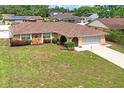 Charming single-story home featuring a stone accent wall, arched entryway, and a well-maintained lawn at 2013 Meredith Dr, Spring Hill, FL 34608