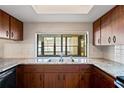 Bright kitchen with granite counters, wood cabinets, stainless steel sink, and view out to the lanai at 2013 Meredith Dr, Spring Hill, FL 34608