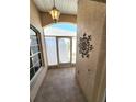 Tiled entryway featuring a decorative light fixture, offering a warm welcome to the home at 355 Royal Palm Way, Spring Hill, FL 34608