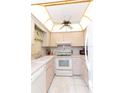 Bright kitchen features white appliances, white cabinetry, and a unique ceiling fan at 4533 Marine Pkwy # 206, New Port Richey, FL 34652