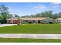 Charming single-story home with a well-manicured lawn and inviting curb appeal at 4603 Lake In The Woods Dr, Spring Hill, FL 34607