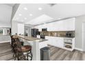 Spacious kitchen featuring white cabinets, a breakfast bar, and modern appliances at 4603 Lake In The Woods Dr, Spring Hill, FL 34607