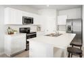 Kitchen featuring stainless steel appliances, white cabinets and an island with sink and seating at 625 171St E St, Bradenton, FL 34212