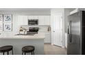 Bright kitchen with white cabinetry, stainless steel appliances, and a spacious center island with seating at 625 171St E St, Bradenton, FL 34212