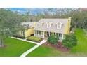 Aerial view of a well-manicured home featuring a classic yellow facade, complemented by verdant lawns at 1031 Pomme De Pin Ln, New Port Richey, FL 34655
