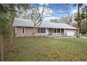 Charming single-story home featuring a welcoming front porch, attached garage and mature landscaping at 13289 Joy Path, Brooksville, FL 34601