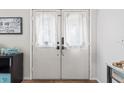 Charming white double front doors featuring sheer curtains, adding a touch of privacy and elegance to the entrance at 13419 Banner Rd, Spring Hill, FL 34609