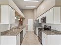 Modern kitchen featuring white cabinets, stainless steel appliances, and beautiful granite countertops at 18325 Whitacre Cir, Hudson, FL 34667