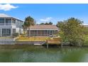 Backyard of waterfront home with dock, seawall, and screened in back porch at 3403 Holly Springs Dr, Hernando Beach, FL 34607
